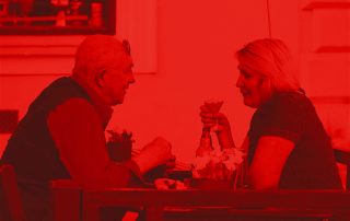 Red tinted photograph of pensioners at a table : Mortgages into Retirement from Martland Mortgages.